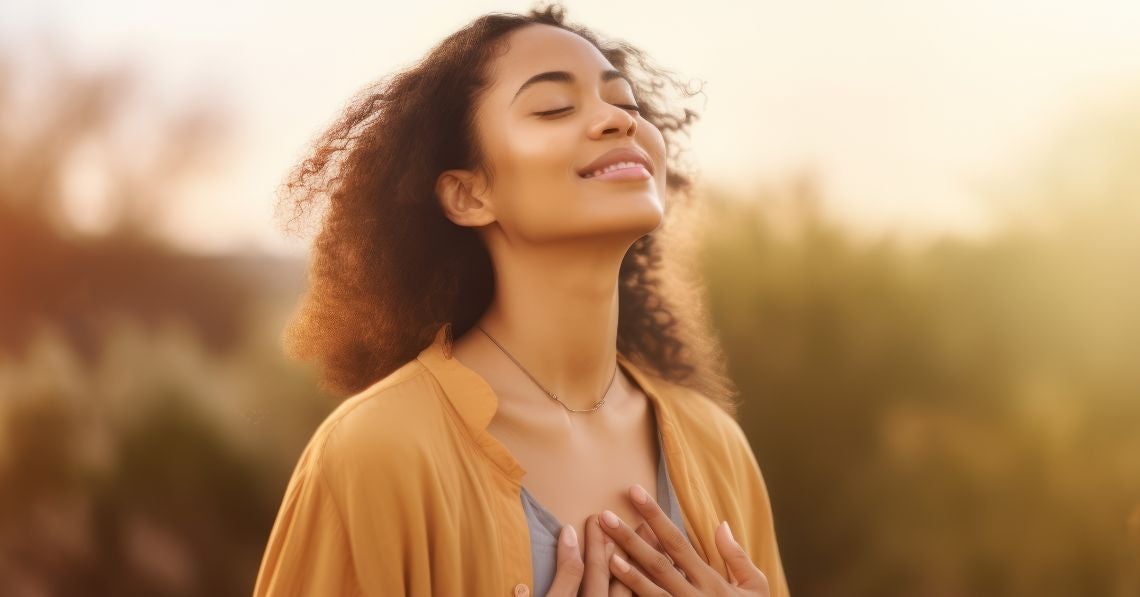 Woman in nature with hands on heart