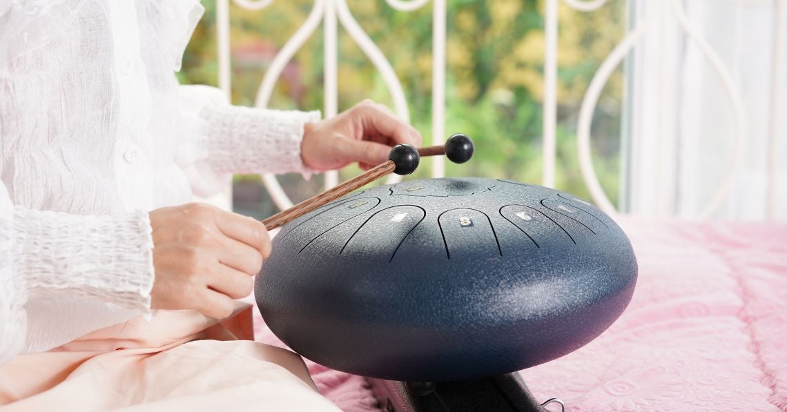 Woman playing tongue drum for sound healing purposes