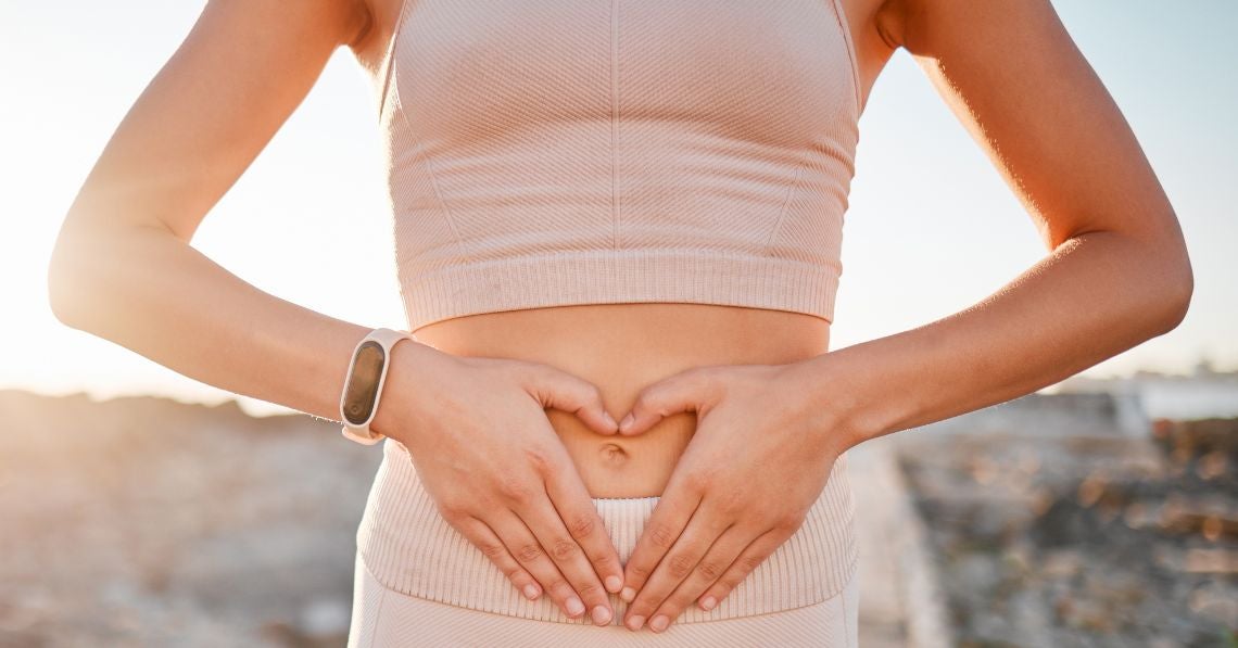 woman with hands in heart shape on belly