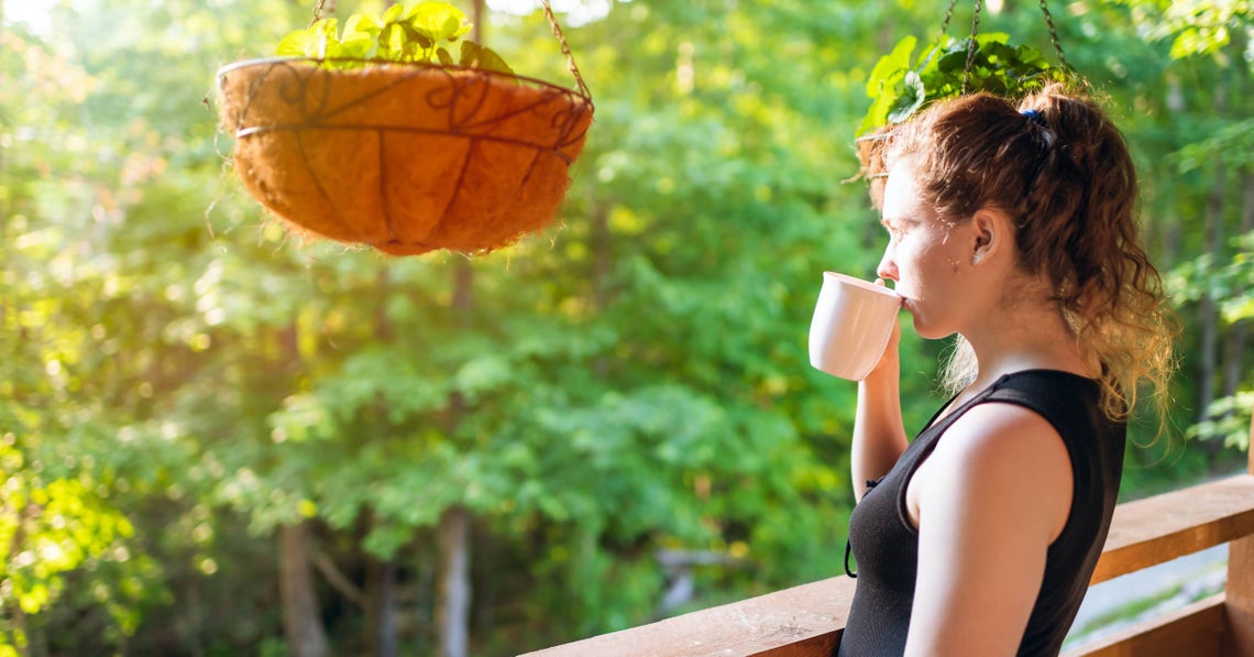 woman drinking coffee on her patio in the morning