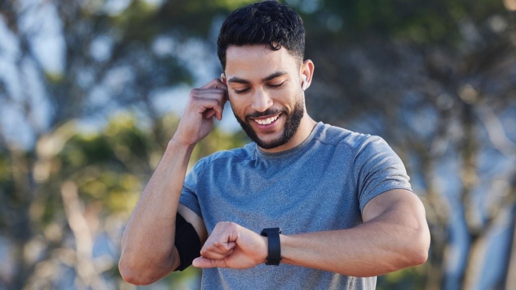 Man exercising looking at his watch